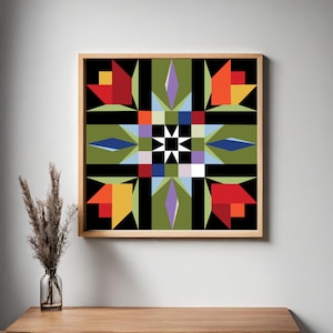 May include: Framed geometric art print. The artwork displays a symmetrical design with red, orange, yellow, blue, and purple shapes on a green and black background. The framed art is displayed on a wooden surface.