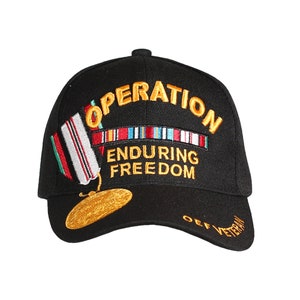 May include: Black baseball cap with gold embroidery that reads "Operation Enduring Freedom" and "OEF Veteran". The cap features a gold embroidered medal with a ribbon of colorful stripes.