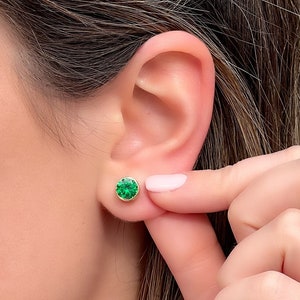 Puede incluir: Un par de pendientes de botón de oro con una piedra preciosa redonda verde.