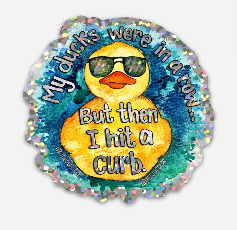 May include: A yellow rubber duck wearing sunglasses with the text "My ducks were in a row... But then I hit a curb."  The duck is on a blue and white background with a silver glitter border.