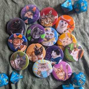 May include: A collection of 14 round pins featuring various cat illustrations. The pins are colourful and feature different cat breeds, including a tabby cat, a calico cat, a Siamese cat, and a black cat. The pins are perfect for adding a touch of personality to your clothing, bags, or other accessories.