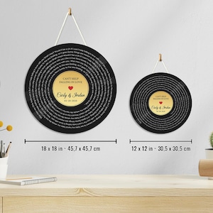 May include: Two circular wall plaques resembling vinyl records with black outer rings featuring song lyrics and gold centers. The larger plaque is 18 x 18 inches, and the smaller is 12 x 12 inches. Both display "CAN'T HELP FALLING IN LOVE", "Carly & Jordan", and "02-28-2020".