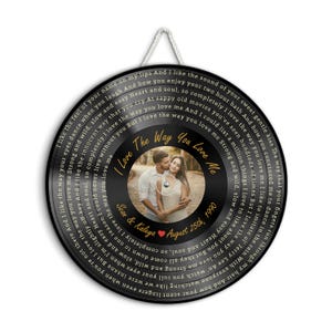 May include: A circular wall hanging shaped like a vinyl record featuring a central photograph of a couple. The text "I Love The Way You Love Me," "Sean & Kaleya," and "August 25th, 1990" is printed in gold, surrounded by lyrics in a spiral pattern.