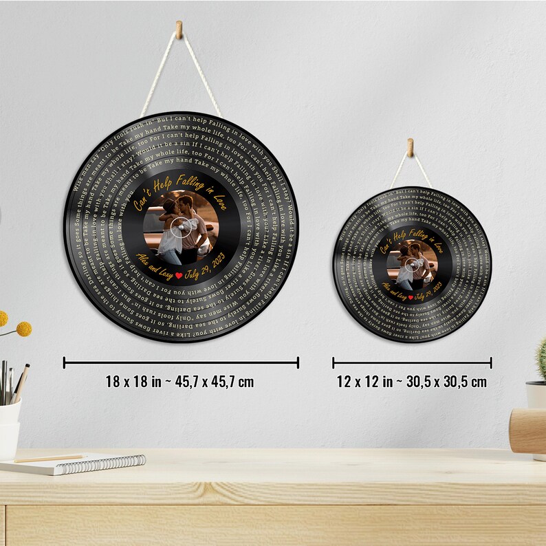 May include: Two circular black wall plaques featuring the lyrics to Can't Help Falling in Love, a central photograph of a couple, and the text Alex and Lexy July 29, 2023. The larger plaque is 18 x 18 inches and the smaller is 12 x 12 inches.