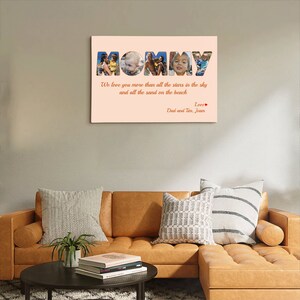 Op de afbeelding: Een roze canvas print met het woord "MOMMY" in grote letters. Elke letter is gevuld met een foto van een kind. De tekst onder de letters luidt "We love you more than all the stars in the sky and all the sand on the beach. Love, Dad and Tom, Jean."