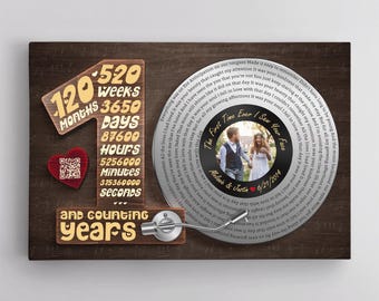 May include: A rectangular wall art piece featuring a large wooden number one, a vinyl record graphic with a central photo of a couple, and text including 120 months, 520 weeks, 3650 days, 87600 hours, 5256000 minutes, 31536000 seconds, and counting years.