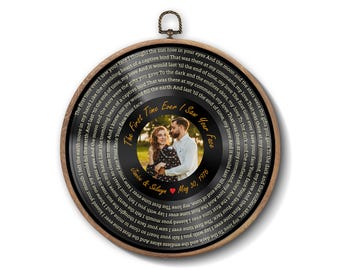 Peut inclure: Une décoration murale circulaire présentant un design de disque vinyle noir encadré de bois. Le centre affiche une photographie d'un couple, le texte The First Time Ever I Saw Your Face, Janice & Selwyn, et May 30, 1976, avec des paroles en cercle.