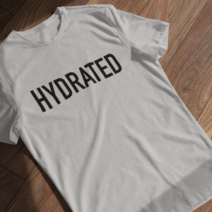 May include: A gray t-shirt with the word "HYDRATED" printed in black on the front.