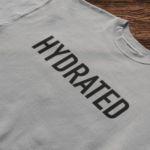 May include: A light gray sweatshirt with the word "HYDRATED" printed in black.