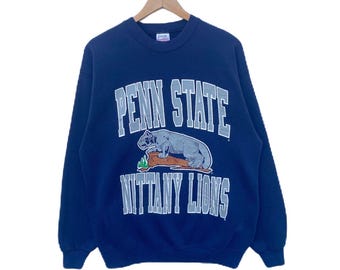 May include: A navy blue sweatshirt with the text "Penn State Nittany Lions" in white and gray lettering. A cartoon lion is pictured on a log.