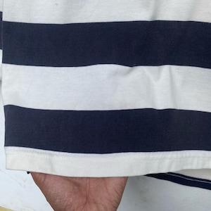 May include: A white and navy blue striped long-sleeve shirt with a ribbed knit texture.