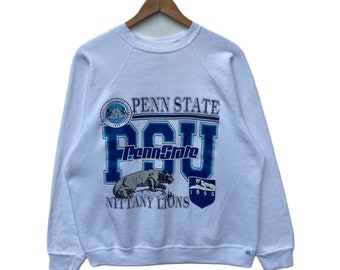 May include: White sweatshirt with a blue and white Penn State Nittany Lions logo. The logo includes the words "Penn State" and "PSU" with a lion graphic and the year "1855".