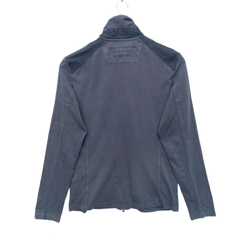 May include: A dark gray long-sleeved jacket with a zipper closure and a black patch on the back that says "HELLY HANSEN" and "HH" in a circle with "AVIREX 2016" underneath.