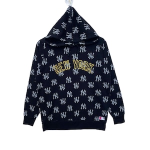 May include: Black hooded sweatshirt with a repeating pattern of the New York Yankees logo. The word "NEW YORK" is written in gold across the front of the sweatshirt.