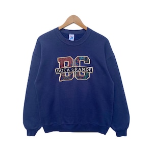 May include: A navy blue sweatshirt with a colorful embroidered logo that says "Boca Grande" and "BG".
