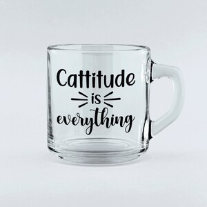May include: Clear glass mug with a black vinyl decal that reads "Cattitude is everything".