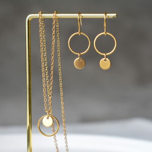 Peut inclure: Un collier en or avec un pendentif rond et deux boucles d'oreilles cr&eacute;oles en or avec un pendentif rond suspendu &agrave; chaque cr&eacute;ole.