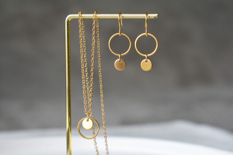 Peut inclure: Un collier en or avec un pendentif rond et deux boucles d'oreilles cr&eacute;oles en or avec un pendentif rond suspendu &agrave; chaque cr&eacute;ole.