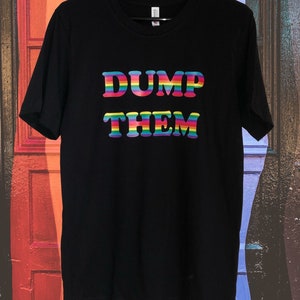 May include: Black t-shirt with the text "DUMP THEM" in rainbow colors. The text is in a retro font style.
