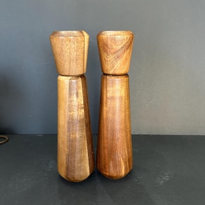 Pu&ograve; includere: Un set di due saliere e pepiere in legno. Le saliere sono in legno marrone scuro con venature del legno naturali. La parte superiore di ogni saliera &egrave; un'apertura rotonda leggermente svasata.