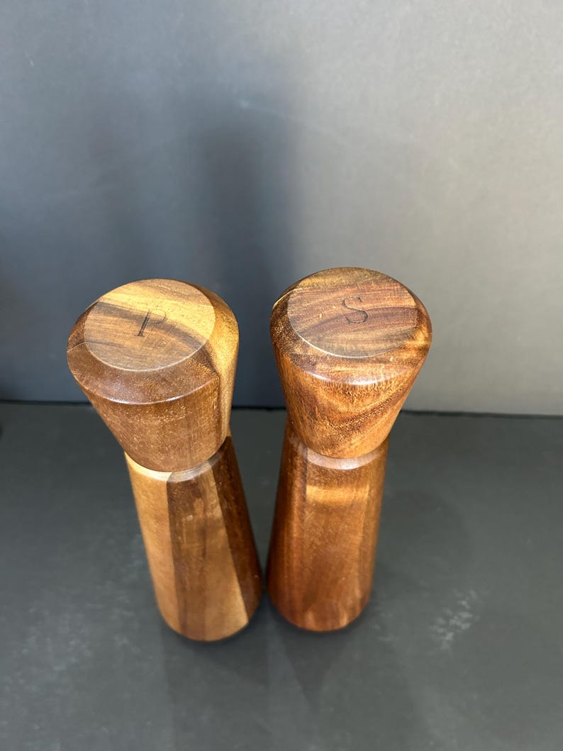 Pu&ograve; includere: Un set di due saliere e pepiere in legno. Le saliere sono in legno marrone scuro e hanno un design semplice e cilindrico. La parte superiore di ogni saliera &egrave; contrassegnata dalle lettere "S" e "P" per sale e pepe.