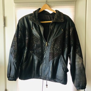 May include: A black leather jacket with a floral design. The jacket has a zipper closure and a drawstring at the bottom.