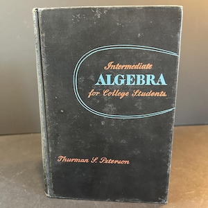 Op de afbeelding: Een zwart boek met een blauwe en witte ovaal op de omslag. De tekst op de omslag luidt "Intermediate Algebra for College Students" door Thurman S. Peterson.