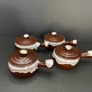 Può includere: Set di quattro ciotole per zuppa in ceramica marrone e bianca con coperchi e manici.