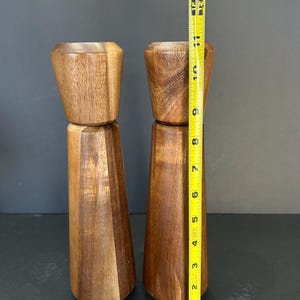 Pu&ograve; includere: Un set di due saliere e pepiere in legno. Le saliere sono in legno marrone scuro e sono alte circa 18 cm.