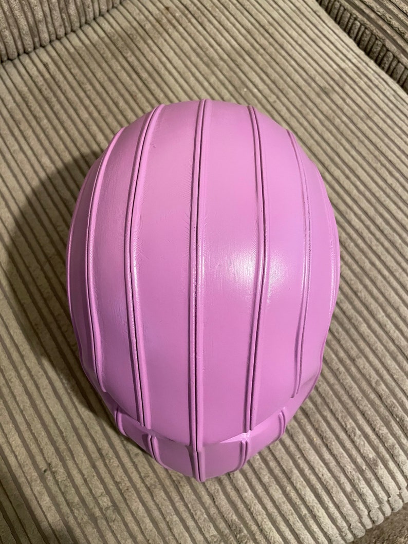 May include: A pink ceramic bowl with a ribbed design. The bowl is round and has a smooth, glossy finish.