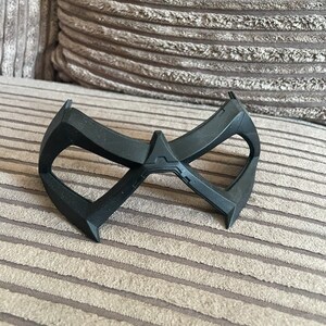 May include: A black plastic mask with a distinctive design, resembling a superhero's mask.