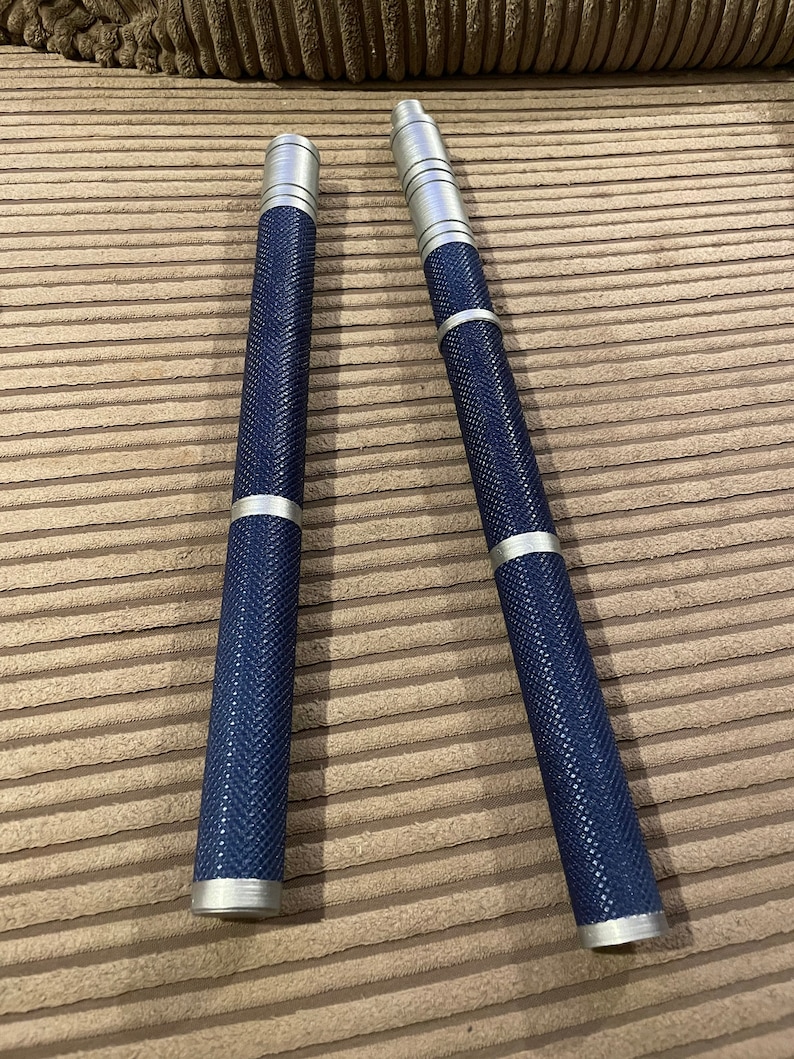 May include: Two silver and blue metal sticks with a textured surface. The sticks are about 12 inches long.