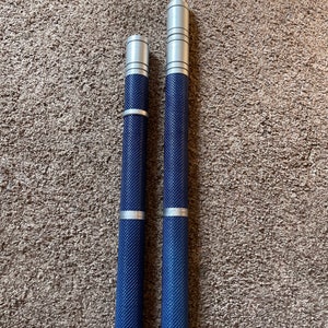 May include: Two silver and blue metal rods with a textured surface. The rods are different lengths.