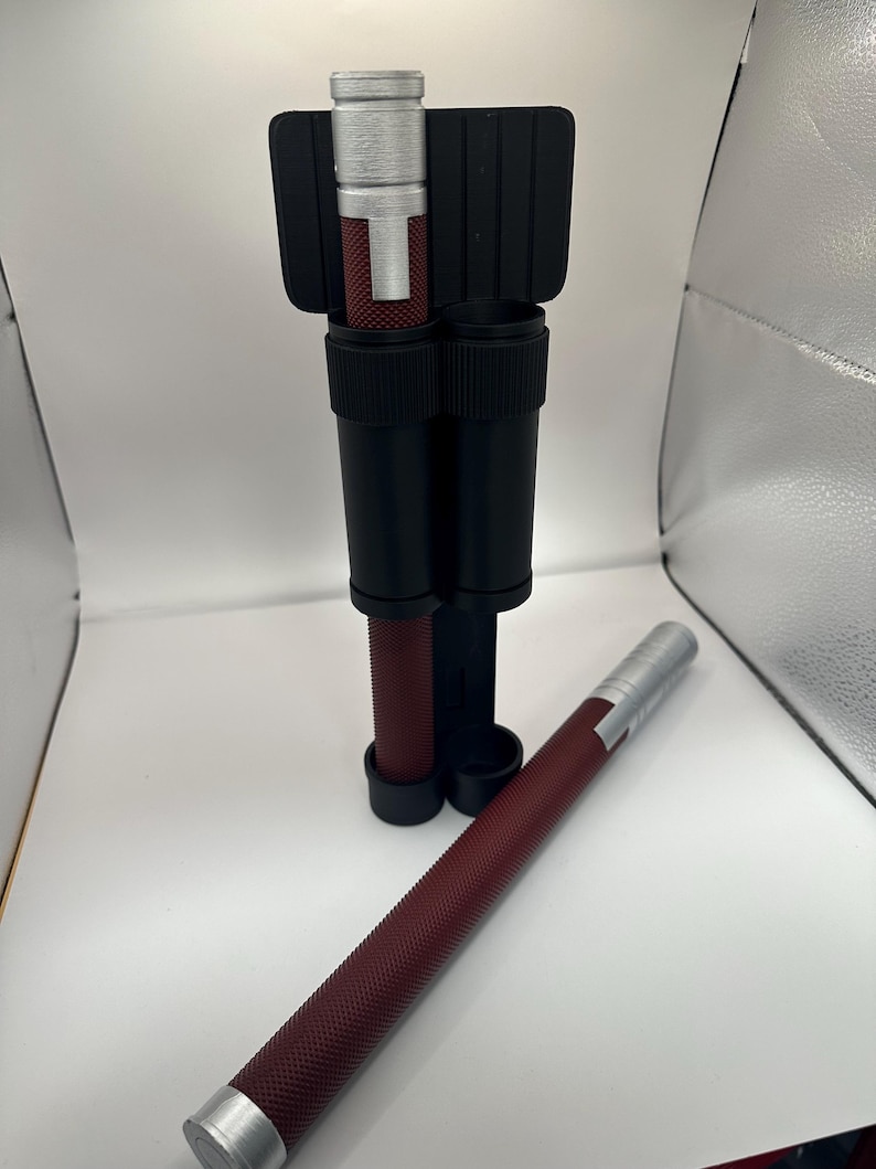 May include: Two silver and maroon retractable batons with a black carrying case. The batons have a textured surface and a silver tip.