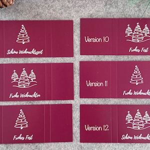 Pode incluir: Cart&otilde;es de Natal bord&ocirc; com ilustra&ccedil;&otilde;es brancas de &aacute;rvores de Natal e sauda&ccedil;&otilde;es festivas. Os cart&otilde;es est&atilde;o rotulados com as vers&otilde;es 7, 8, 9, 10, 11 e 12. O texto inclui "Sch&ouml;ne Weihnachtszeit" e "Frohes Fest".