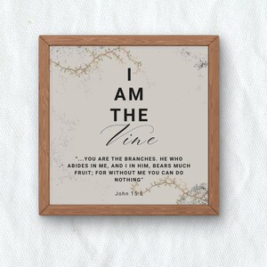 May include: A framed print with the words "I AM THE Vine" in black script. The print includes a Bible verse from John 15:5 and decorative floral accents. The frame is made of wood.