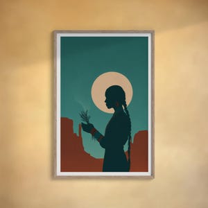 May include: A framed art print featuring a silhouette of a person holding a sprig against a backdrop of a teal sky and a large, pale yellow sun. The person is in profile, with long braids, and the background includes red rock formations.