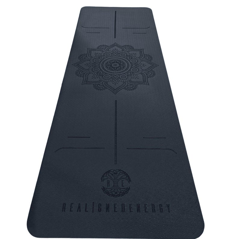 May include: A dark blue yoga mat featuring a central mandala design. The mat includes alignment guides and the text "REALIGNEDENERGY". This mat is designed for yoga and fitness activities. The mat measures approximately 173 cm in length.