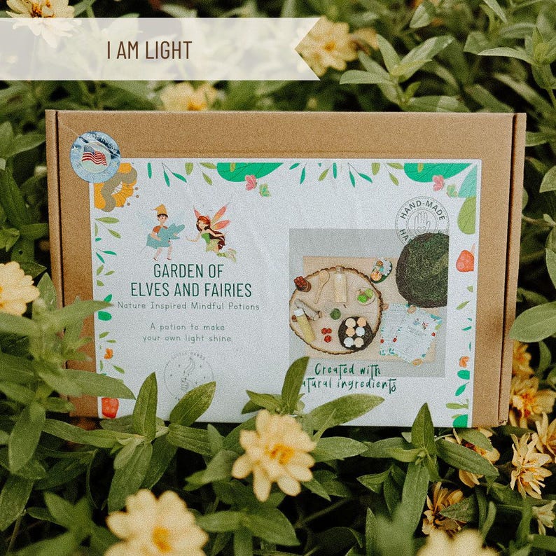 May include: A brown cardboard box with a white label that says "Garden of Elves and Fairies" and "Nature Inspired Mindful Potions". The box is open and shows a variety of items, including a wooden tray, a small green plant, and a small bottle of liquid. The label also says "A potion to make your own light shine" and "Created with natural ingredients".