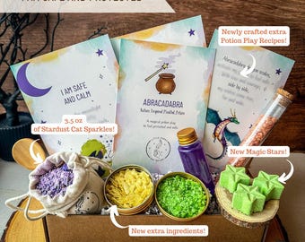 Puede incluir: Un kit de juego de pociones en una caja de cartón que contiene tres tarjetas impresas, una bolsa beige con contenido morado, dos latas pequeñas con gránulos amarillos y verdes, una botella morada y tres objetos verdes en forma de estrella sobre madera.