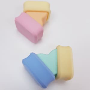 Puede incluir: Dos juegos de anillos apilables de silicona de colores. Un juego es amarillo, naranja y rosa. El otro juego es amarillo, azul claro y verde.