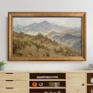 Pode incluir: Um móvel de TV de madeira clara com uma pintura de paisagem acima. O móvel tem gavetas, prateleiras abertas e um armário. A pintura retrata uma cordilheira em cores suaves, emoldurada em ouro.