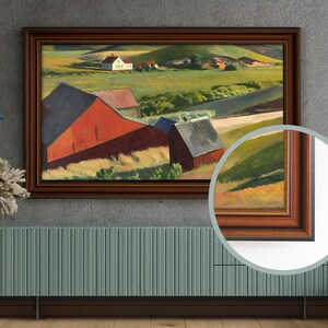 Puede incluir: Pintura de paisaje enmarcada que representa una escena rural con graneros rojos, una casa blanca y colinas verdes. La obra de arte está encerrada en un marco de madera marrón oscuro.