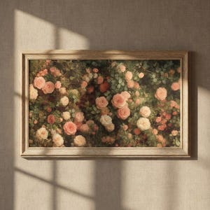 Pode incluir: Uma impressão floral emoldurada com uma densa disposição de rosas em vários tons de rosa, pêssego e creme. As rosas são colocadas em um fundo de folhagem verde, criando uma composição exuberante. A moldura é de madeira clara.
