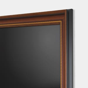 Può includere: Uno specchio rettangolare con una superficie grigio scuro, incorniciato da una cornice in legno marrone scuro con un bordo dorato. La cornice ha un bordo esterno nero.