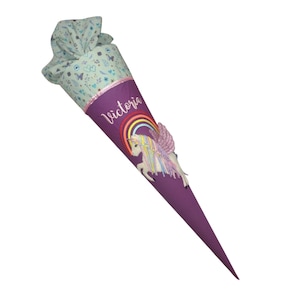 Könnte beinhalten: Eine kegelförmige Schultüte in Lila mit einem Einhorn- und Regenbogen-Design. Auf der Tüte steht der Name "Victoria". Der obere Teil ist aus hellblauem Stoff mit floralem Muster.