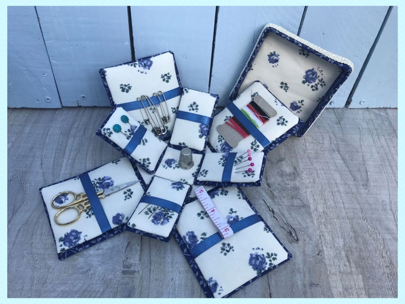 Completed blue and white etui box or exploding sewing box. the box is open with sewing equipment inside it.
