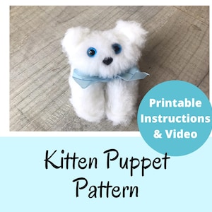 May include: A white fluffy kitten puppet with bright blue eyes and a small black nose, wearing a light blue ribbon around its neck. The image includes the text "Printable Instructions & Video" and "Kitten Puppet Pattern" in black and white.