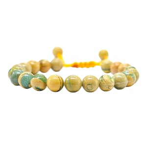 May include: A green and yellow beaded bracelet with a yellow cord closure.