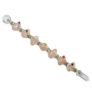 May include: A pink quartz crystal wand with a clear quartz crystal tip and silver accents. The wand is adorned with small colorful gemstones.